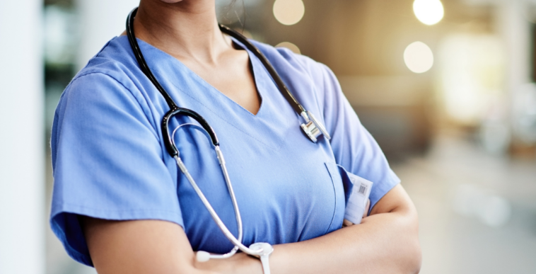 A nurse standing and folding her arms.