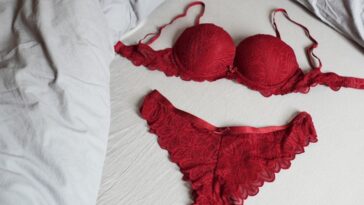 Red bar and panty lingerie set on bed.