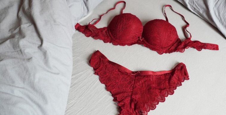 Red bar and panty lingerie set on bed.