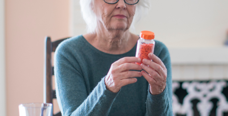 Older woman holding a prescription pill bottle