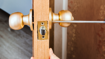 person changing lock on interior door