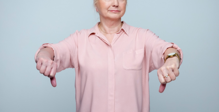 older woman giving two thumbs down