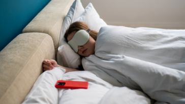 young woman sleeping with her cellphone next to her