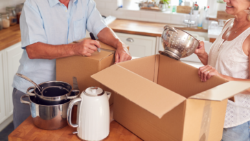 An older couple packing moving boxes.