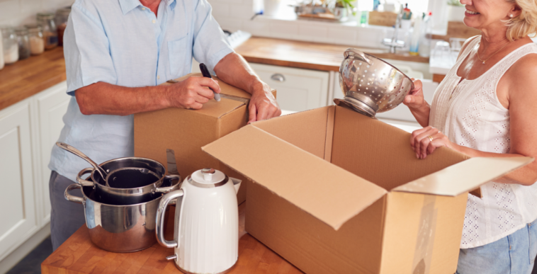 An older couple packing moving boxes.