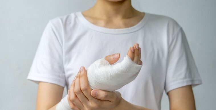 Shot of an unidentifiable woman holding her wrapped, wounded hand.