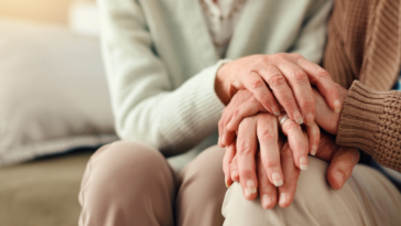 An elderly couple holding hands.