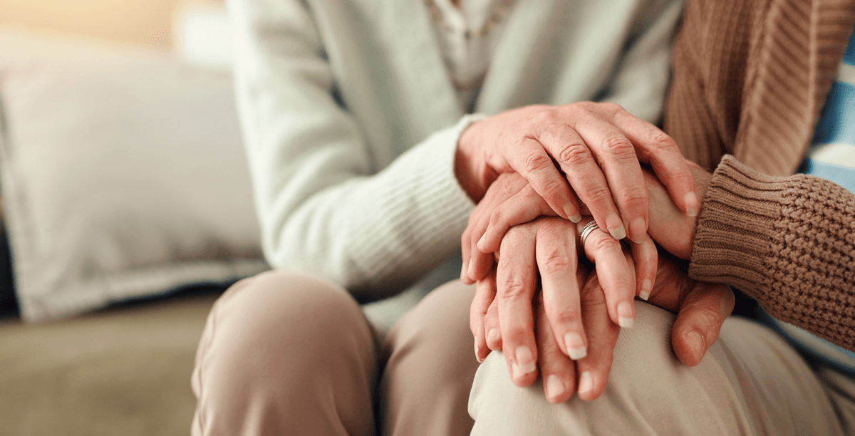 An elderly couple holding hands.