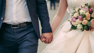 A bride and a groom holding hands.