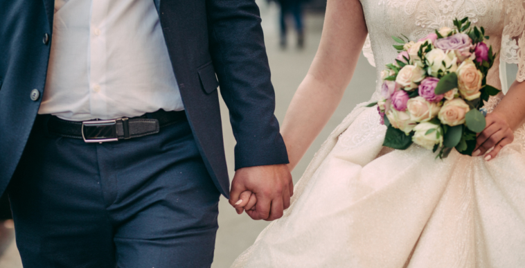 A bride and a groom holding hands.