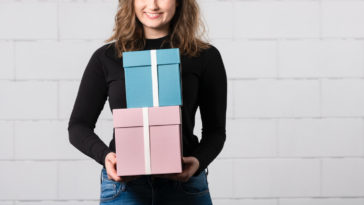 A woman holding a pink and blue box.