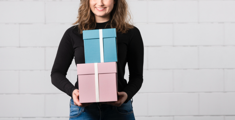 A woman holding a pink and blue box.