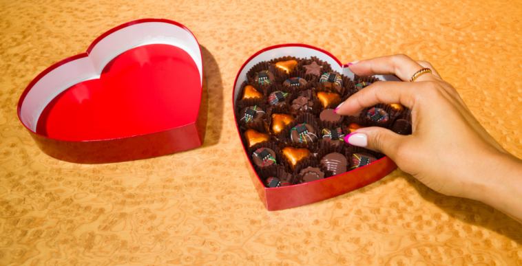 Person reaching into a box of chocolates