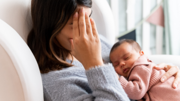 tired mother holding infant