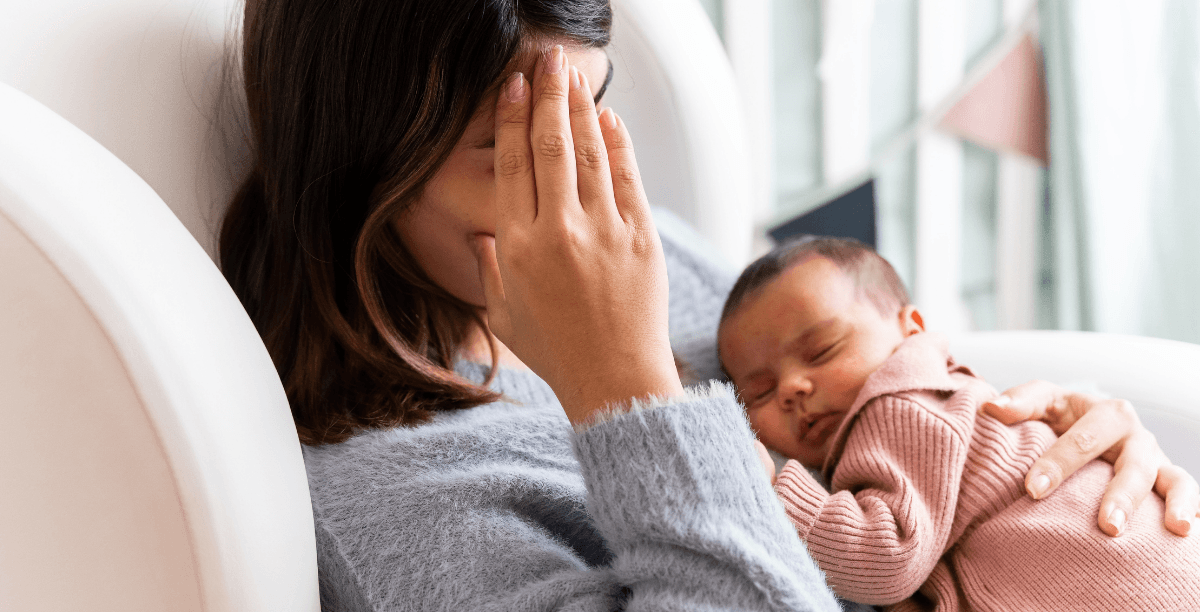 tired mother holding infant