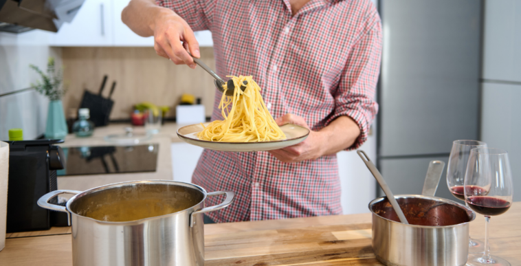 man plating food in kitchen