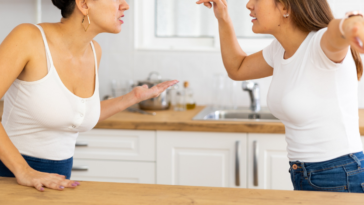 two women argue in kitchen