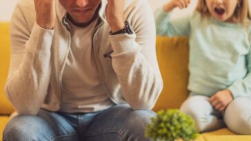 Stressed father is feeling desperate because of his screaming daughter.