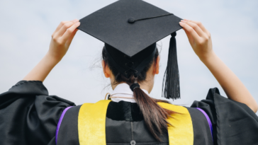 A woman in a graduation cap and gown.