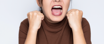 A woman clenching her fists and screaming.