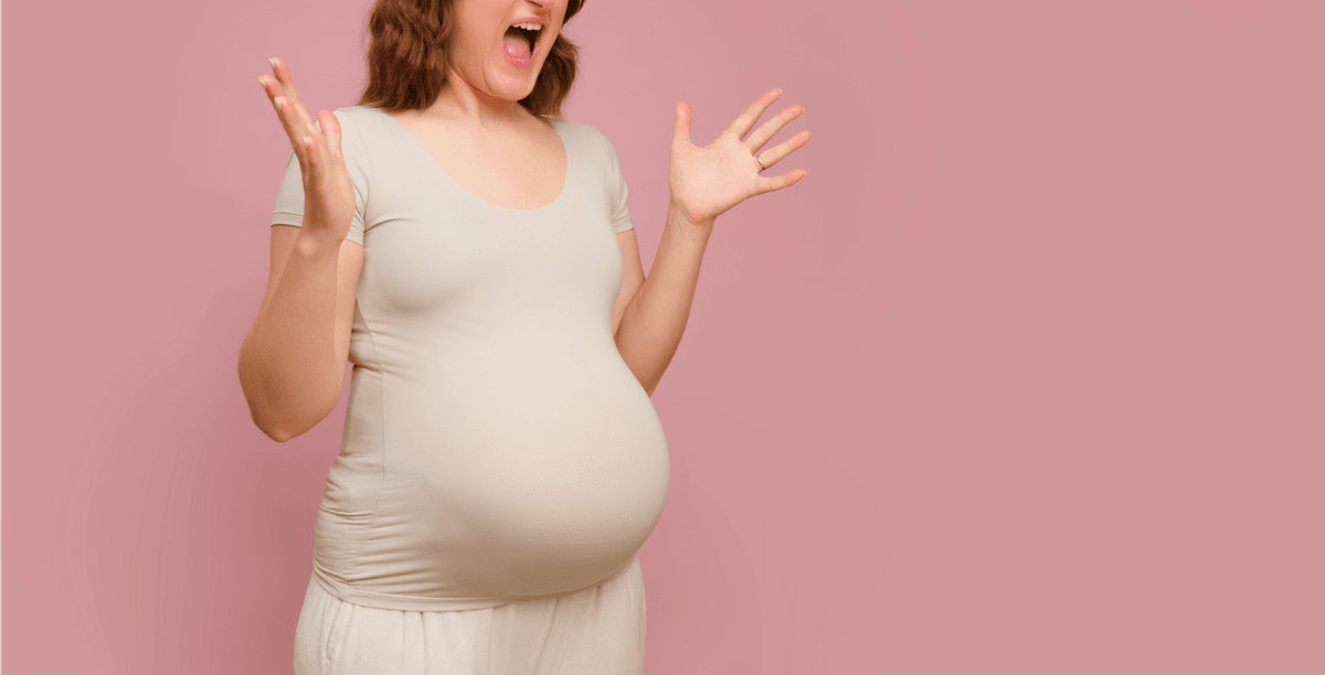 A pregnant woman emphatically holding out her arms and screaming.