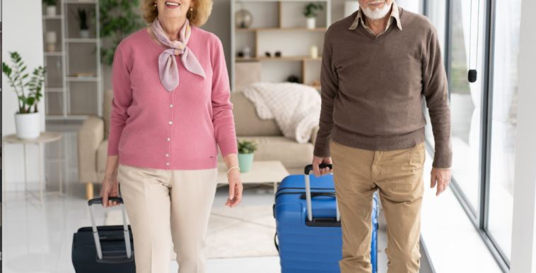 An older couple pulling rolling luggage.