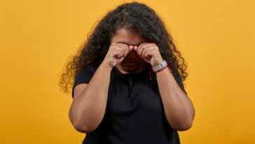 A woman covering her face and crying.