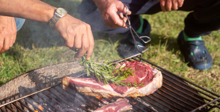 Men grilling steaks