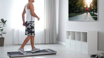 Guy in a white shirt on a walking pad in front of the television
