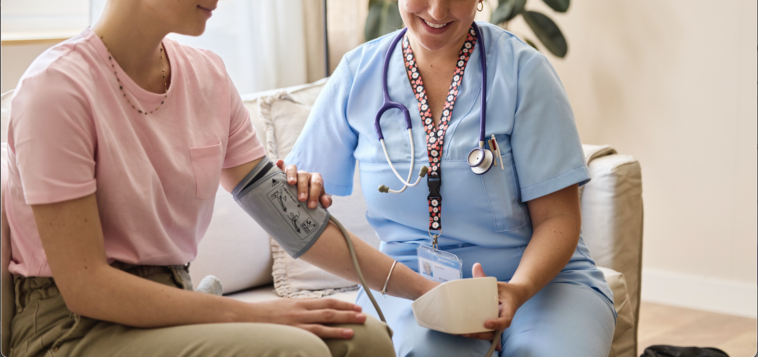 A nurse sitting next to a woman with a chemo IV in her arm.