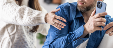 Man hiding his phone from his wife