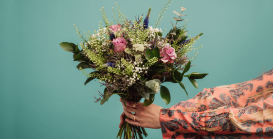woman holding out bouquet of flowers